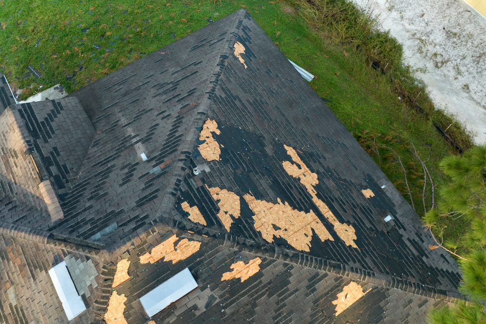 Damaged,house,roof,with,missing,shingles,after,hurricane,ian,in